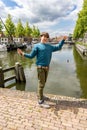 A teenager is fishing on a canal in Amsterdam Royalty Free Stock Photo