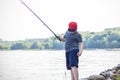 A teenager is fishing on the lake with a fishing rod. Recreation and outdoor walks in the city park Royalty Free Stock Photo