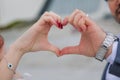 The teenager folded her hands in the shape of a heart against the background .Happy couple making heart with their hands outdoors Royalty Free Stock Photo