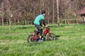 Teenager frolic on old-fashioned red motorbike in the field. Young boy enjoy rides on motorcycles. Jawa 50 pioneer. Riding a