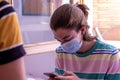 Teenager front other in the social distance in a mask staring at a copyspace camera in his room. Concept of new normality and Royalty Free Stock Photo