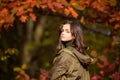 Teenager girl on autumn red maple leaves at fall outdoors. Portrait of a beautiful teen. Royalty Free Stock Photo