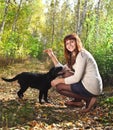 Teenager girl and black labrador retriever puppy