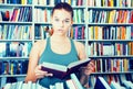 Teenager girl brunete looks for the right book in library