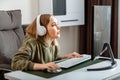 Teenager girl cybersportman gamer play online computer game at home alone in leisure time. Young blonde woman in Royalty Free Stock Photo