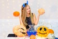 Teenager girl in demon costume posing with pumpkins