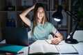 Teenager girl doing homework at home late at night confuse and wondering about question Royalty Free Stock Photo