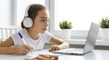 Teenager girl doing homework at home. She is looking at the laptop Royalty Free Stock Photo