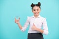 Teenager girl drinking water from glass on blue background. Daily life health. Drink water for health care and body Royalty Free Stock Photo