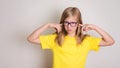 Teenager girl in eyeglasses closed her ears not to listen with c Royalty Free Stock Photo