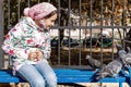 Teenager girl feeding pigeons in the park. The girl sits on a bench and feeds the birds with seeds. Autumn sunny day Royalty Free Stock Photo