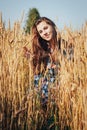 Teenager girl in a field full of yellow ears Royalty Free Stock Photo