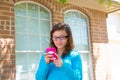 Teenager girl with glasses playing with smartphone