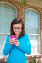 Teenager girl with glasses playing with smartphone