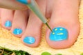 Teenager girl hand with enamel laque brush pedicure her toes foot