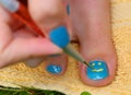 Teenager girl hand with enamel laque brush pedicure her toes foot Royalty Free Stock Photo