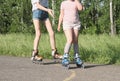 teenager girl and her little sister rollerskating in the park. partial view. sport and leisure concept. preshcool girl Royalty Free Stock Photo