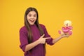 Teenager girl hold soft toy for birthday on yellow background. Teen with toy teddy bear with love heart for valentines Royalty Free Stock Photo