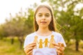 teenager girl holding paper homemade garland with two children and parents outdoors craft hobby