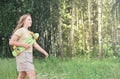 teenager girl holding a skateboard and going for a skating in a park. blond curly teen girl with long hair enjoiying