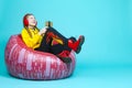 Modern Addiction Concepts. Teenager Girl in Hooded Jacket With Gamepad Joystick While Using Cellphone For Gaming in Cushion Chair Royalty Free Stock Photo