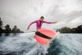 Teenager girl jumping on the orange wakeboard Royalty Free Stock Photo