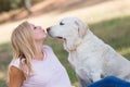 Teenager girl kissing her very old senior labrador dog in the park