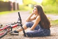 Teenager girl ride bicycle on country road through the forest