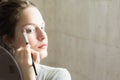 Teenager girl looking her self in a mirror applying eyeshadow wi Royalty Free Stock Photo