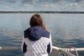 Teenager girl looking at the ocean from a deck of a yacht. Galway bay, Ireland. The model back to viewer. Blue cloudy sky. Girl Royalty Free Stock Photo