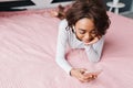 Teenager, girl lying on big pink bed, listening to music Royalty Free Stock Photo