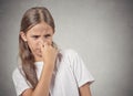 Teenager girl pinches nose, something stinks