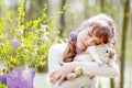 Teenager girl  play with real rabbit in the garden. Cute child at Easter egg hunt with  pet bunny. Spring outdoor fun for kids Royalty Free Stock Photo