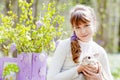 Teenager girl  play with real rabbit in the garden. Smiling child at Easter egg hunt with  pet bunny. Spring outdoor fun for kids Royalty Free Stock Photo