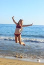 Cute Teenager Girl playing In Sea Waves. Jump Accompanied By Water Splashes. Summer  Day, Happy childhood, Ocean Coast concept Royalty Free Stock Photo