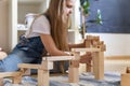 Teenager girl playing track constructor block tower with metallic ball Maria Montessori materials