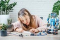 A teenager girl plugging cables to sensor chips while learning arduino coding and robotics