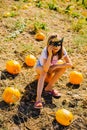 Teenager girl and pumpkin in the vegetable garden. A girl with a pumpkin wearing glasses for Halloween Royalty Free Stock Photo