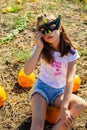 Teenager girl and pumpkin in the vegetable garden. A girl with a pumpkin wearing glasses for Halloween Royalty Free Stock Photo