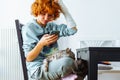 Portrait teenage girl with red hair, cast on arm and domestic cat at home Royalty Free Stock Photo