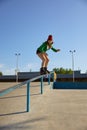 Teenager girl in roller skates riding on handrail practicing extreme tricks Royalty Free Stock Photo