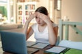 Teenager girl with shocked face studying online at home looking at laptop at quarantine