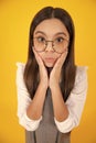 Teenager girl with shocked facial expression. Surprised face expression, isolated on yellow background. Royalty Free Stock Photo