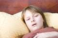 Teenager girl sick with flu lying in bed ill