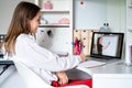 Teenager girl studying online at home looking at teacher giving lesson at laptop screen at quarantine isolation period.