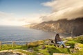 Teenager girl tourist enjoys amazing view on Slieve League cliff, county Donegal, Ireland. Stunning Irish nature landscape.