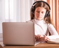 Girl wearing headphones using laptop to watch online seminar. E-learning concept. Distance education Royalty Free Stock Photo