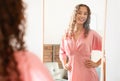 teenager girl wears fashionable dress admiring herself in mirror indoors Royalty Free Stock Photo