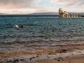 Teenager girl in wet suit with small kids surf board swimming in the ocean. Salthill, Galway city, Ireland. Blackrock diving board Royalty Free Stock Photo