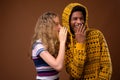 Teenager girl whispering to happy African man who is laughing Royalty Free Stock Photo